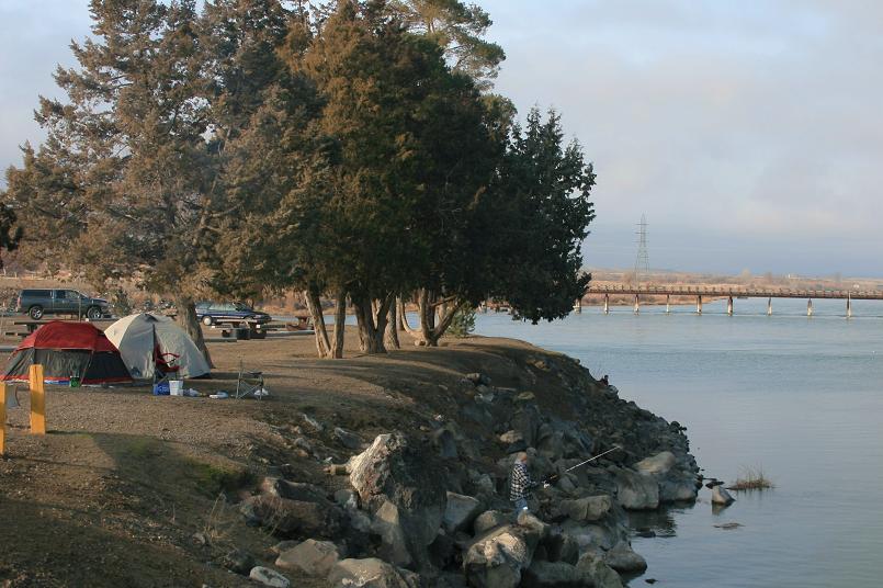 picture of campground with campers and a fisherman at scout park